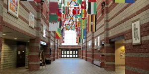 great hall with flags from all around the world's countries and red and cream striped walls