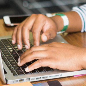 Hands typing on keyboard laptop